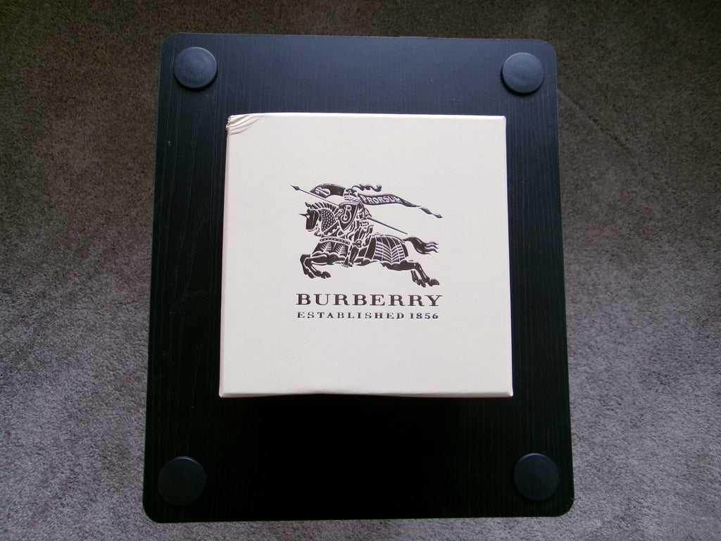 Burberry product on a black stand with a gray background