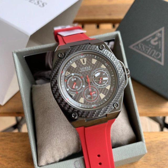 Wristwatch with red strap and detailed face in a box.